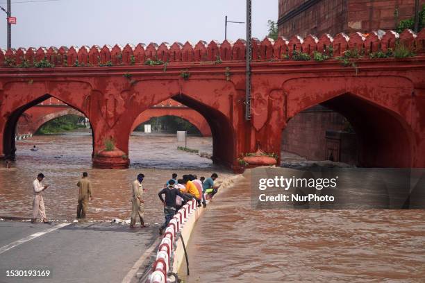 Members of the fire department inspect flood waters under a bridge behind Red Fort, after a rise in the water level of the river due to heavy monsoon...