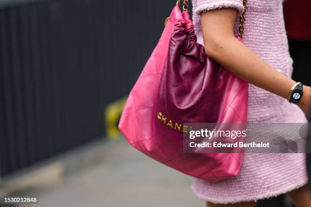 Guest wears a pale pink tweed t-shirt from Chanel, a purple and pink tie and dye print pattern shiny leather Chanel 22 shoulder bag from Chanel,...