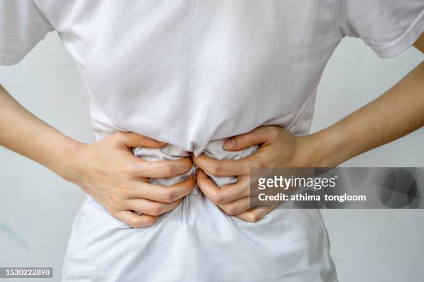 woman holding stomach in pain. - gastroentérite photos et images de collection