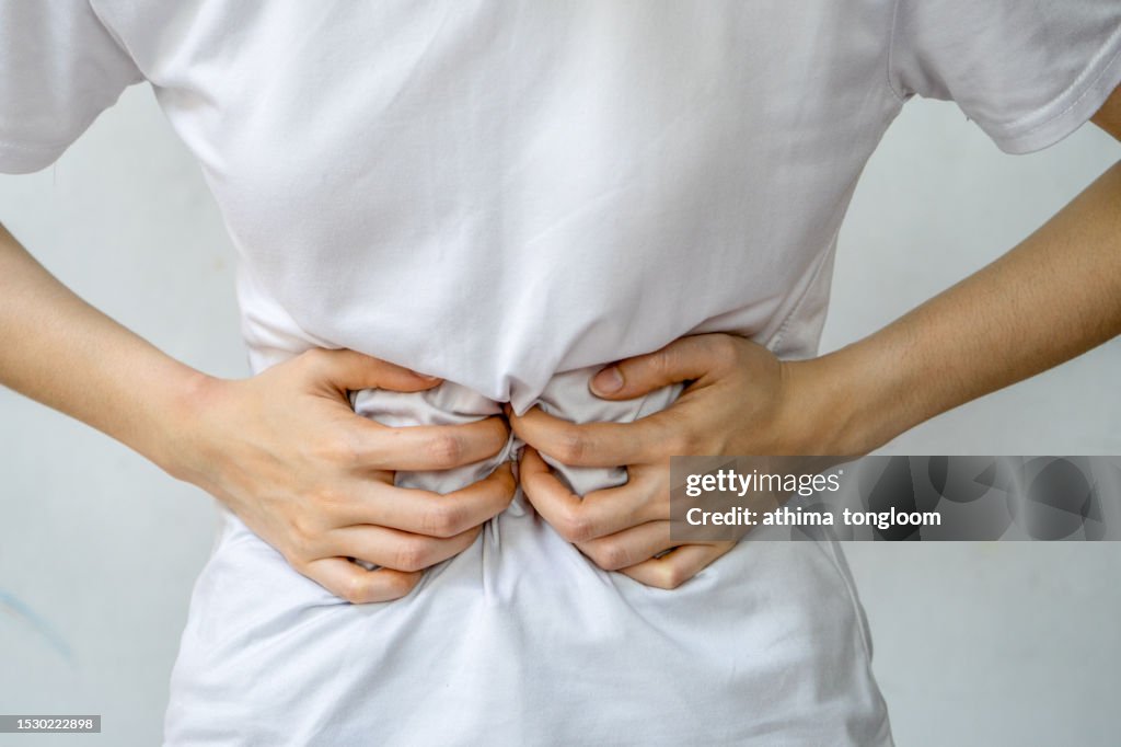Woman holding stomach in pain.