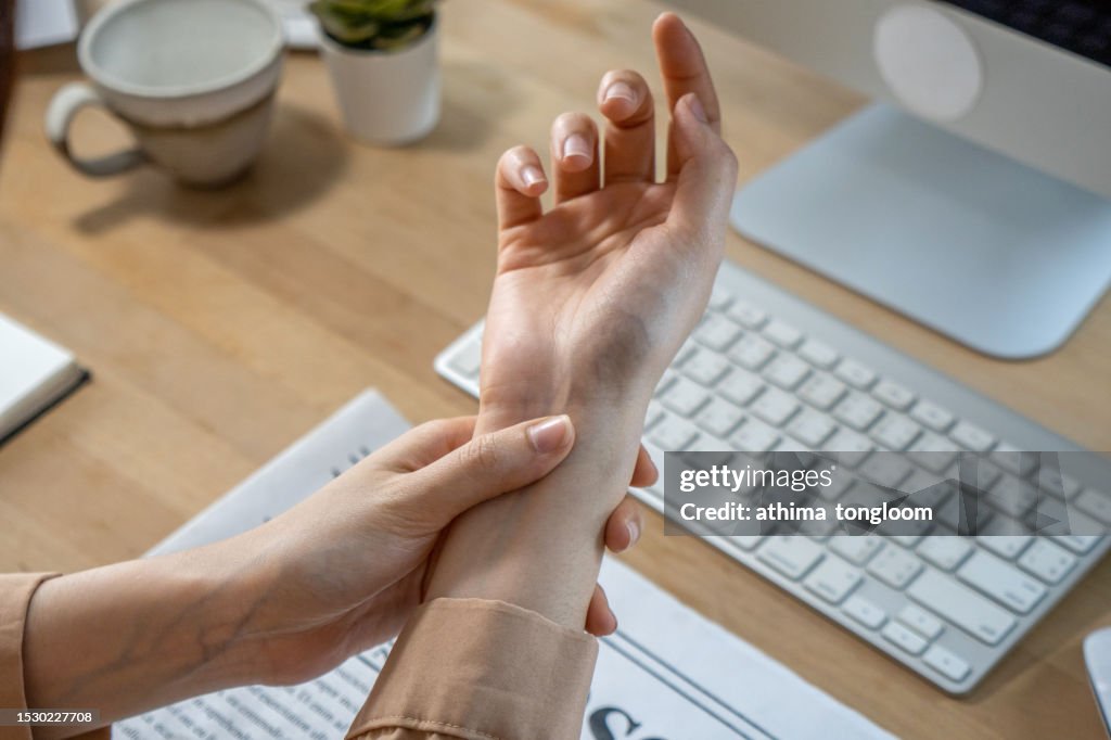 A close-up of a woman holding her wrist pain.