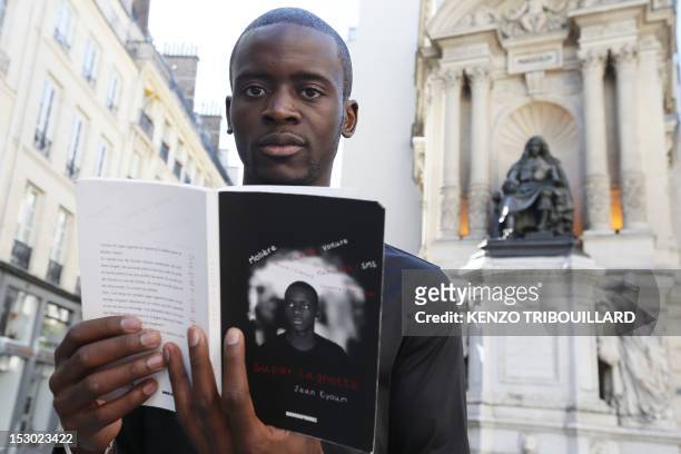 French Cameroonian-born student Jean Eyoum poses with his book on September 29, 2012 in Paris. Eyoum wrote "super cagnotte" a street-talk version of...