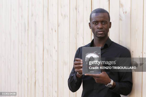 French Cameroonian-born student Jean Eyoum poses with his book on September 29, 2012 in Paris. Eyoum wrote "super cagnotte" a street-talk version of...