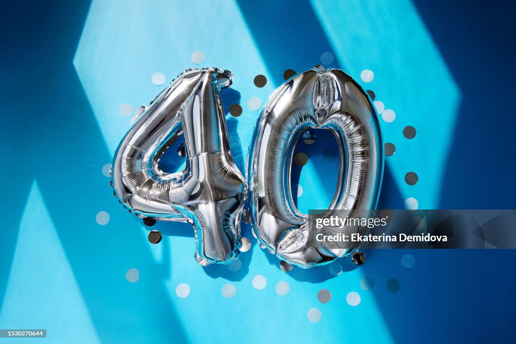 Silver numbers 40 fourty years balloons in sunlight blue background