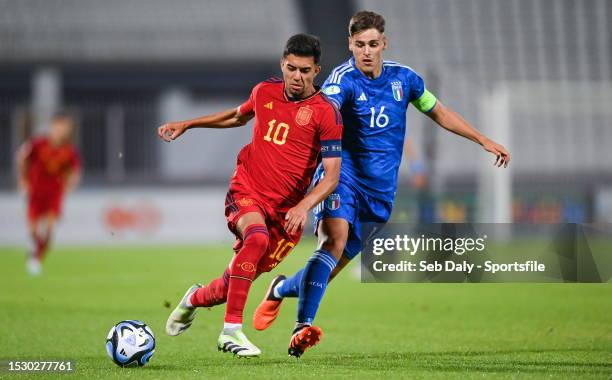 Ilias Akhomach of Spain in action against Giacomo Faticanti of Italy during the UEFA European Under-19 Championship 2022/23 semi-final match between...