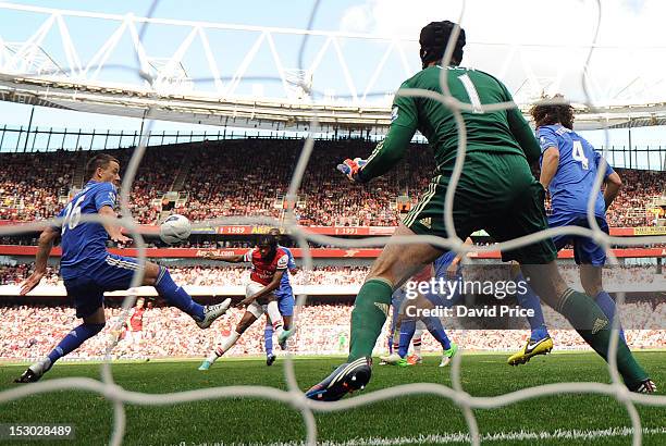 Gervinho scores Arsenal's goal past John Terry and Petr Cech of Chelsea during the Barclays Premier League match between Arsenal and Chelsea at...