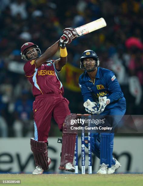 Dwayne Bravo of the West Indies hits out for six runs watched by Sri Lanka wicketkeeper Kumar Sangakkara during the ICC World Twenty20 2012 Super...