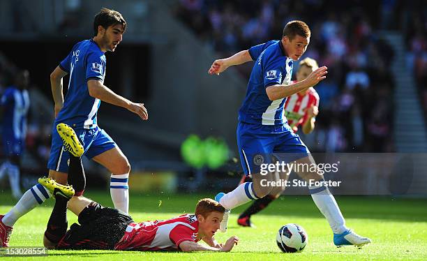 Sunderland player Jack Colback is thwarted by Wigan players Jodi Gomez and James McCarthy during the Barclays Premier League game between Sunderland...