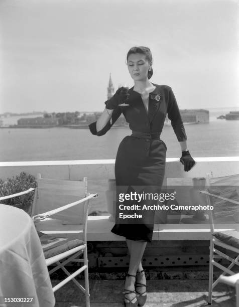 Model wearing Christian Dior fashions near the Piazza San Marco in Venice, 3rd June 1951. The island of San Giorgio Maggiore is visible in the...