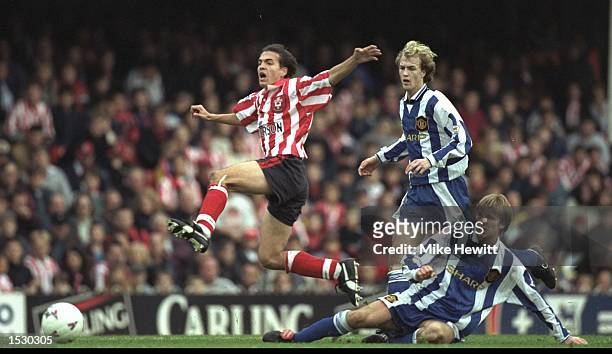 Eyal Berkovic of Southampton leaps over the tackle of David Beckham of Manchester United whilst Jori Cruyff looks on during the FA Carling Premier...
