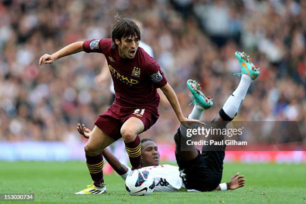 David Silva of Manchester City goes past the challenge from Hugo Rodallega of Fulham during the Barclays Premier League match between Fulham and...