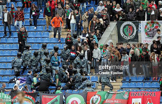 Riot police officers clash with fans during the Russian Premier League match between FC Zenit St. Petersburg and FC Lokomotiv Moscow at the Petrovsky...