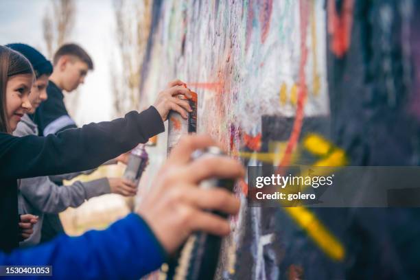 kids spraying graffiti outdoors in park - graffiti bildbanksfoton och bilder