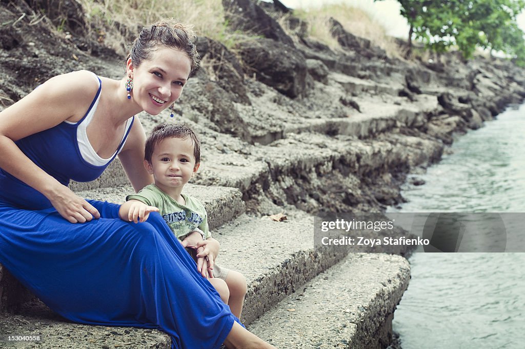 Mother and son sitting on coast