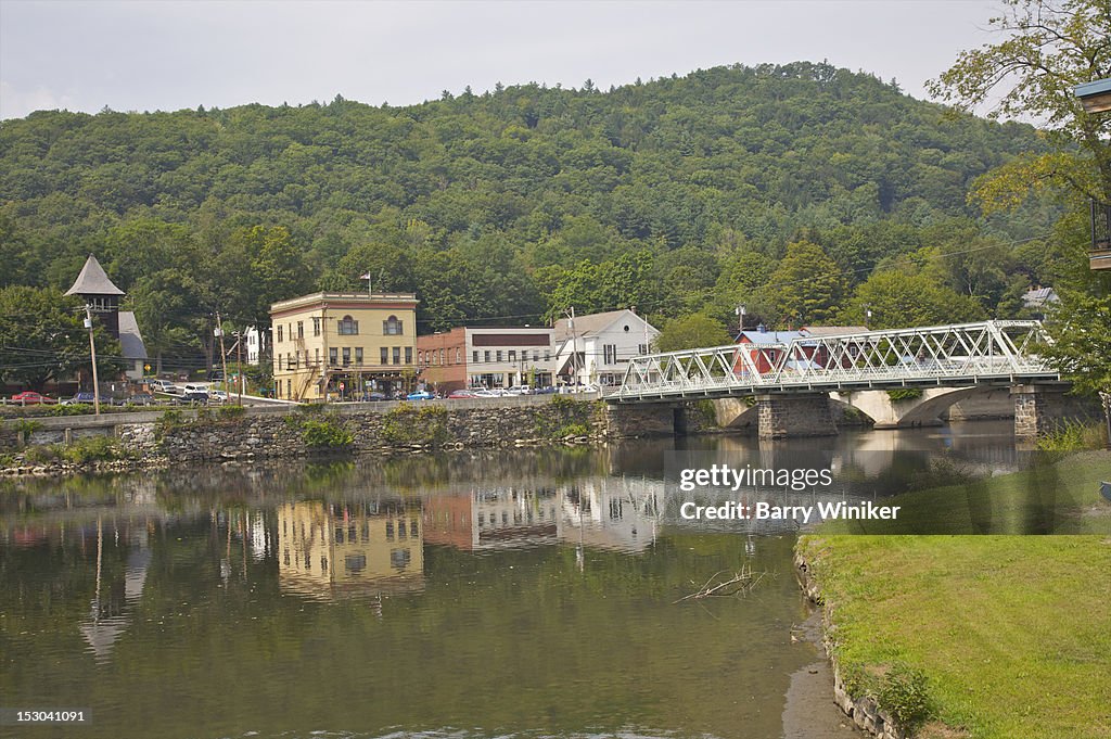 Reflection of small town and bridge in water.