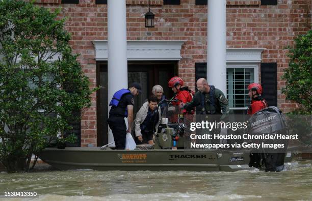 Harris County Sheriff's Office deputies evacuate Carrie and Larry LeBlanc from their flooded home Friday, Sept. 20 in Huffman, Texas. The Luce Bayou...