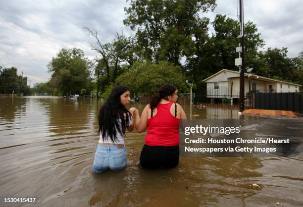 Two women major their way through a flooded street Thursday, Sept. 19 in Houston. Tropical Storm Imelda brought heavy rain to the greater Houston...