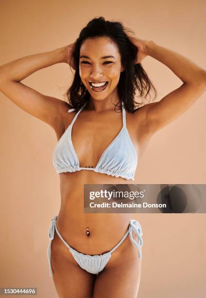 young woman standing in bikini. stock photo - belly ring stock pictures, royalty-free photos & images