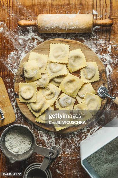 homemade tortellini  on wooden desk with rolling pin, flour and baking utensils - tortellini bildbanksfoton och bilder