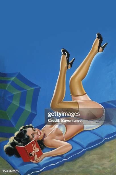 Young woman in high heels & two piece suit on the beach reading a book with a picture of a girl that looks just like her with her legs in the air,...