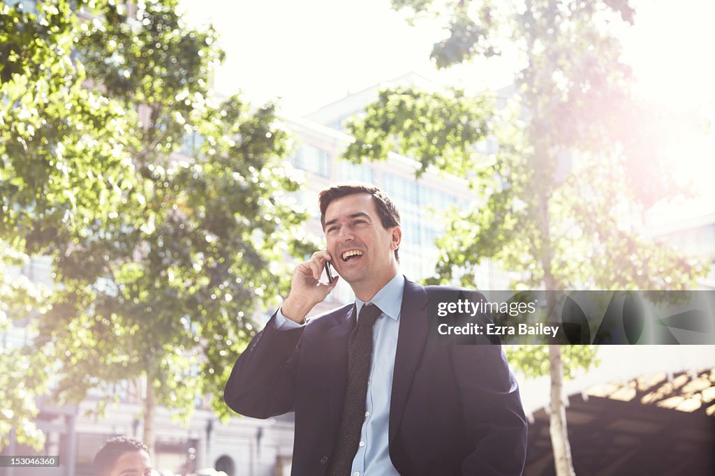 Businessman on a mobile phone outside.