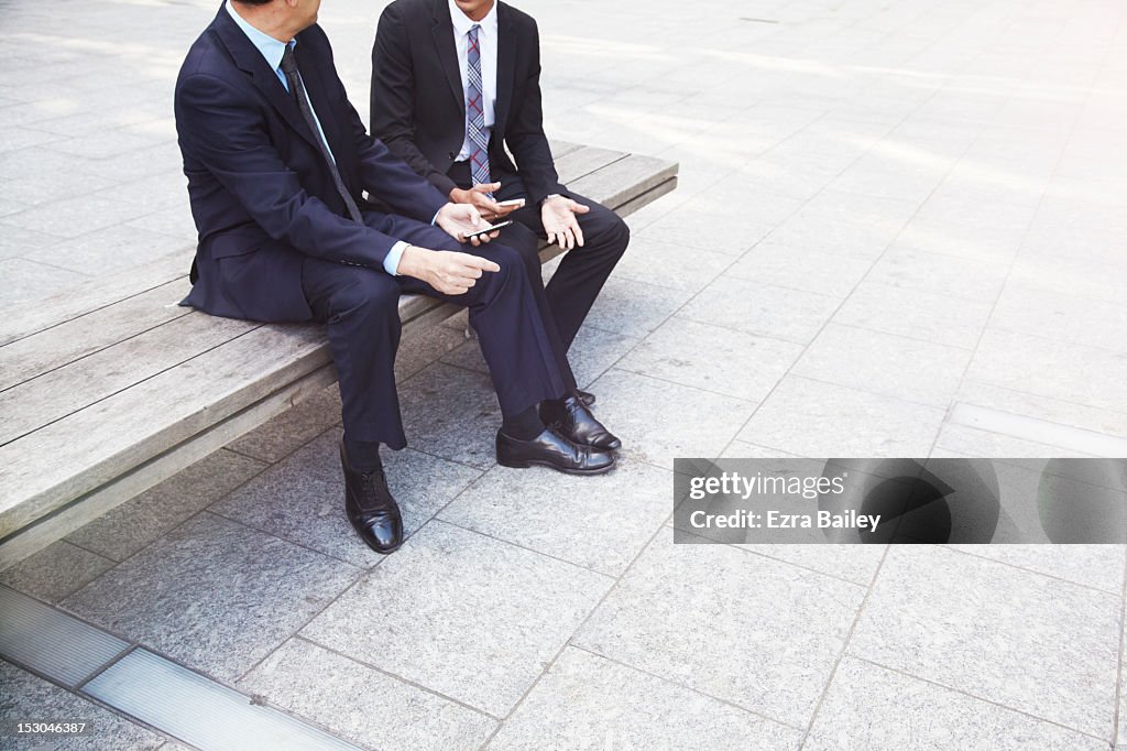 Two businessmen working outside.