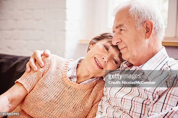 romantic senior couple reminiscing on sofa - memories stock pictures, royalty-free photos & images
