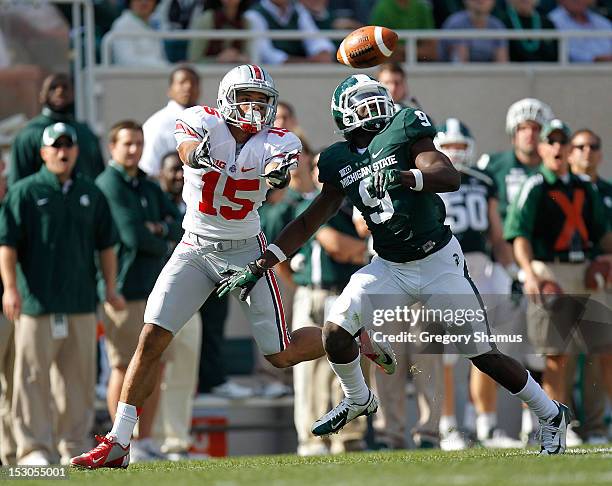 Devin Smith of the Ohio State Buckeyes can't make a first quarter catch in front of Isaiah Lewis of the Michigan State Spartans at Spartan Stadium on...