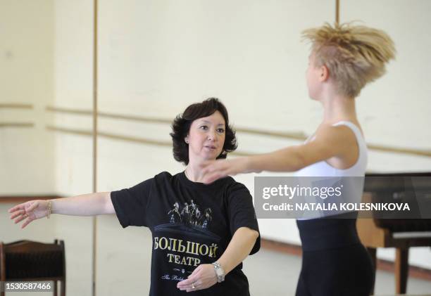 Teacher and one of the young students of the Bolshoi Ballet Academy attend a class in their school in Moscow, on October 18, 2011. The teacher's...