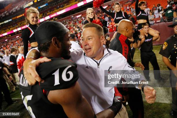 Head coach Butch Jones of the Cincinnati Bearcats celebrates with receiver Damon Julia, who caught a game-winning touchdown to beat the Virginia Tech...