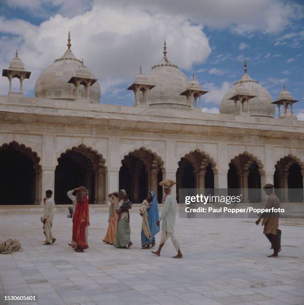 Visitors cross the courtyard in front of the Moti Masjid mosque located within the walls of Agra Fort, also known as the Red Fort, in the city of...