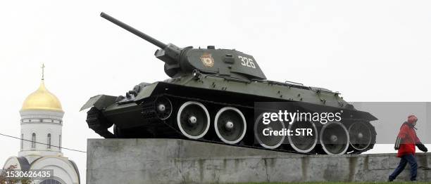 Teenager passes by the famous Russian tank T-34 dating from the World War II era on a pedestal near a church on the Poklonnaya hill in Moscow, 18...