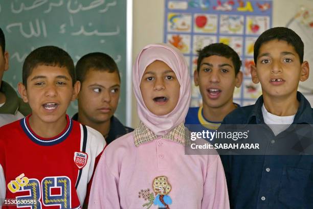 Iraqi children, some traumatized by their country's conflict and others with Down Syndrome sing at a classroom at al-Rajaa Institute for Special...