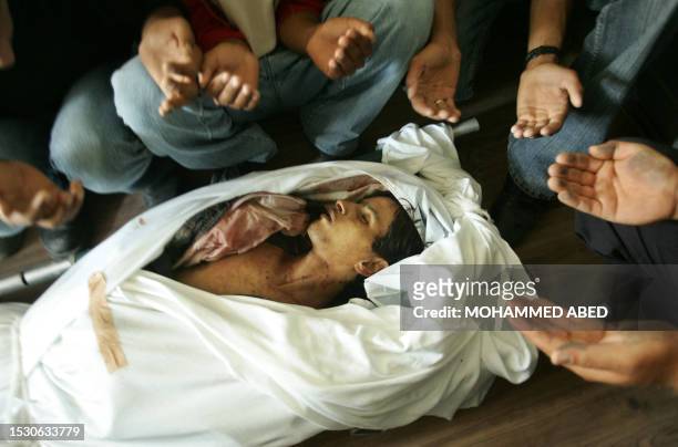 Palestinians mourners pray over the body of 18-year-old Issa al-Omar during his funeral in the Gaza Strip town of Deir el-Balah, 10 October 2005. The...