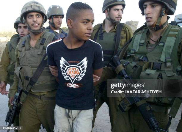 Palestinian teenager is arrested by Israeli soldiers at the Hawara checkpoint, south of Nablus in the West Bank 24 May 2005. Israeli soldiers...