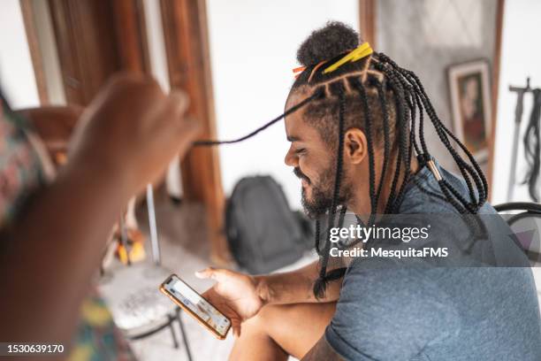 afro man with braids surfing the net - entrançado imagens e fotografias de stock