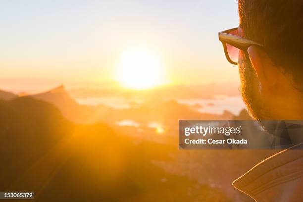 man looking at sunrise en rio de janeiro - rocinha río de janeiro fotografías e imágenes de stock
