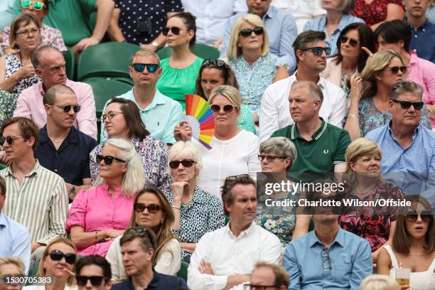 Woman with a rainbow coloured fan sits within the crowd during day eleven of The Championships Wimbledon 2023 at All England Lawn Tennis and Croquet...