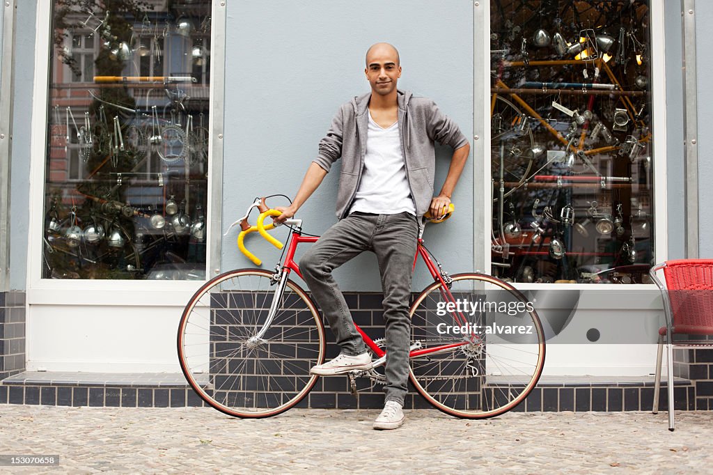 Young trendy guy with a bicycle