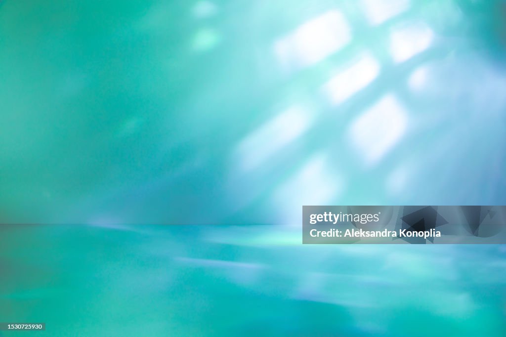 Empty Studio 3d exhibition background - emerald green, turquoise, mint, blue stage with with abstract diagonal light and shadows, crystal caustics effect. Dreamy surreal backdrop