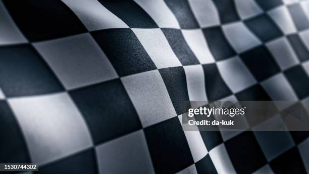 waving racing finish flag with checkered pattern texture in slow motion - pista-de-automobilismo imagens e fotografias de stock