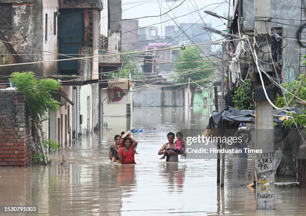 National Disaster Response Force personnel rescue people from the flooded waters of Yamuna River after heavy monsoon rains at Jaitpur khadda colony,...