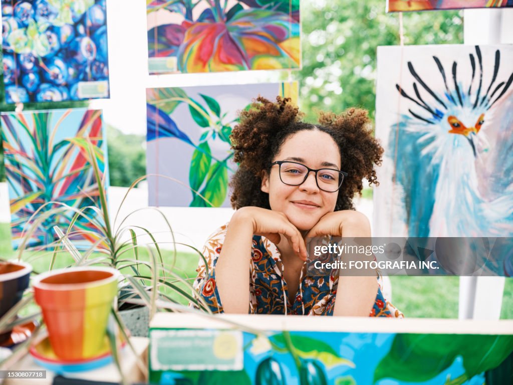 Young Latin woman artist selling her art at Outdoor Market