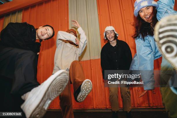 cool dancers are having fun dancing against an orange wall - festa de rua imagens e fotografias de stock