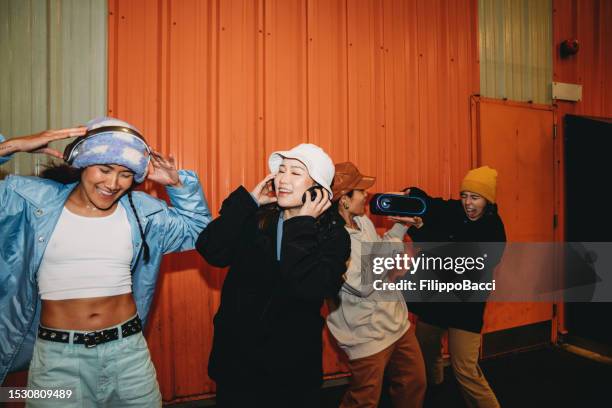 coole tänzer haben spaß daran, vor einer orangefarbenen wand zu tanzen - music band stock-fotos und bilder