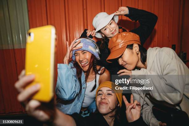 young adult women wearing cool street style clothes are taking a selfie at night - street fashion asian stock pictures, royalty-free photos & images