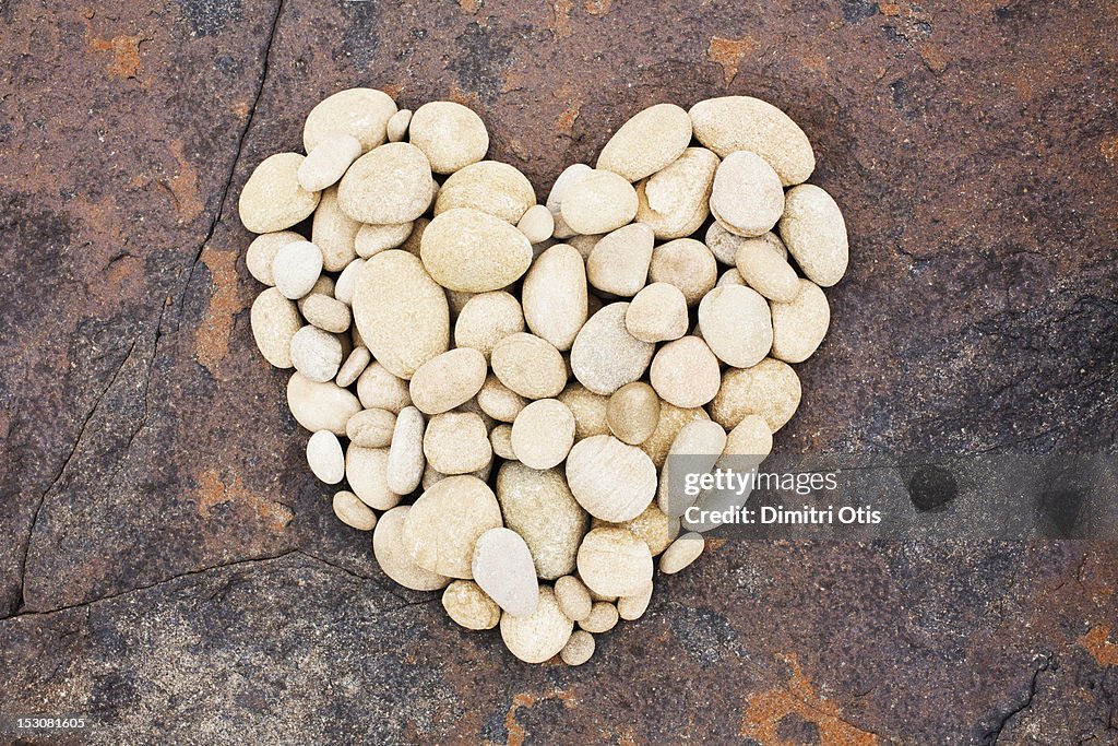 Pebbles laid in heart shape on red boulder