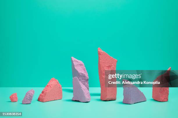 3d stage with minimalistic, simplified abstract asymmetrical composition of  pastel coral pink and lavender purple rocks on a turquoise mint green background - asymmetri bildbanksfoton och bilder