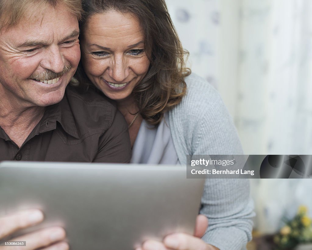 Senior couple having fun using tablet