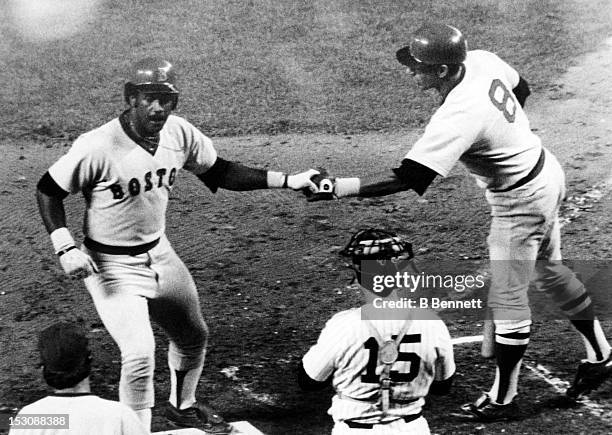 Carl Yastrzemski of the Boston Red Sox gives his teammate Jim Rice a hand shake after Rice hit a two-run home run during the game against the New...